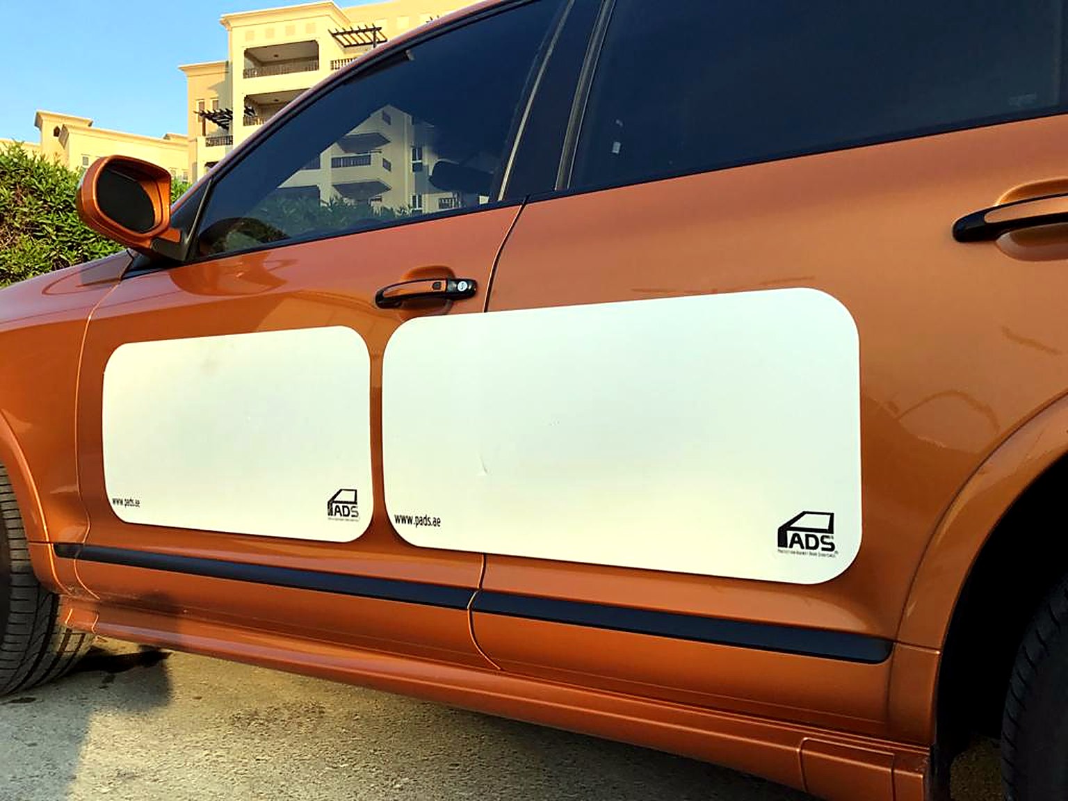 Two white PADS on the doors of an orange SUV